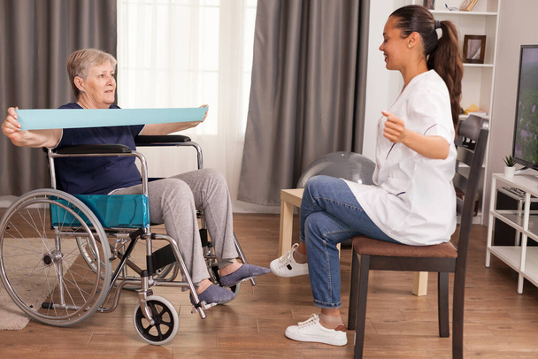 Doctor haciendo rehabilitación con mujer en silla de ruedas
 - Foto, imagen
