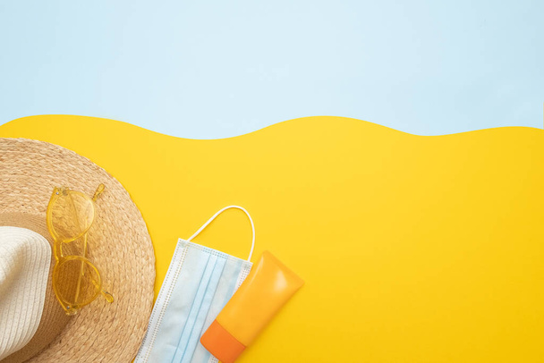太陽の保護対象。麦藁ビーチ帽子、サングラス、保護spfクリーム、明るい黄色の青の背景に外科用マスク。ビーチアクセサリー。夏の旅行の休暇コロナウイルス隔離の概念.  - 写真・画像