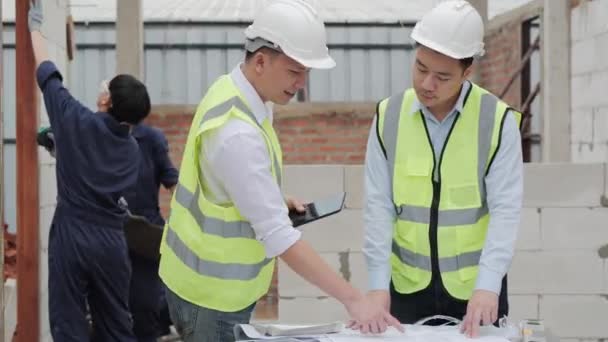 Lidé v těžkých kloboucích diskutují o pracovním procesu na staveništi  - Záběry, video