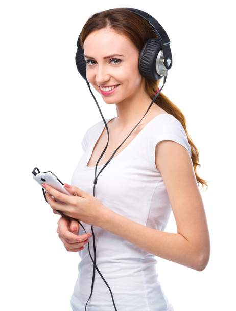 Young woman enjoying music using headphones - Фото, изображение