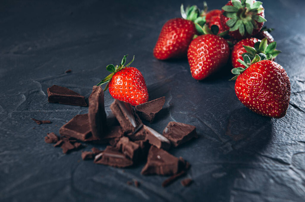 Veel aardbeien met chocolade op een donkere achtergrond van bovenaf bekeken. Bovenaanzicht - Foto, afbeelding