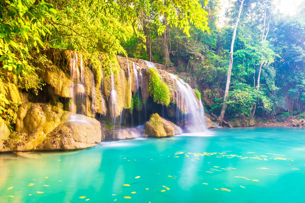 Tropikalny krajobraz z pięknym wodospadem, dzikim lasem deszczowym z zielonymi liśćmi i płynącą wodą. Park Narodowy Erawan, Kanchanaburi, Tajlandia - Zdjęcie, obraz
