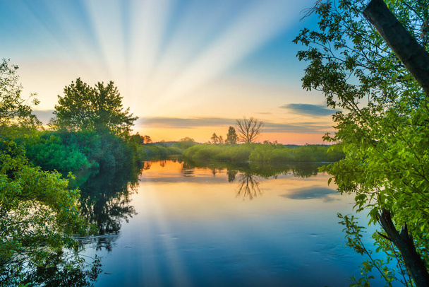 Озеро вода захід сонця і сонячні промені на природі пейзаж з заходом сонця небо
 - Фото, зображення