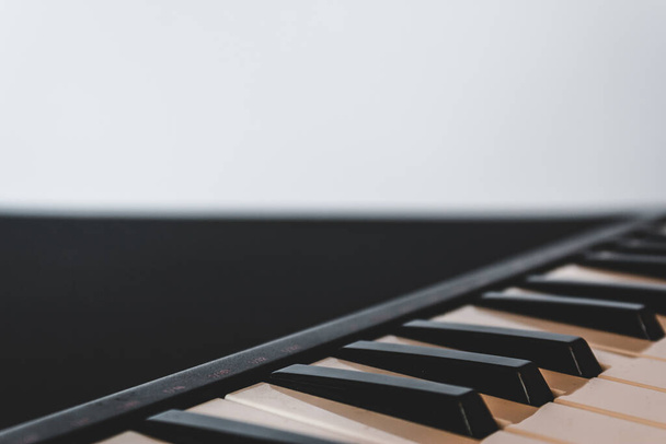 Retro piano keyboard with black and white keys on a white background with copy space Musical instrument used for creative melodic compositions - Foto, Imagem