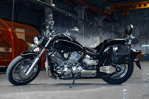 Motorcycle standing in a dark hangar building - Foto, Bild