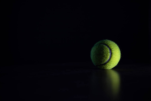 tennis ball isolated on dark background in hard light - Foto, Imagem