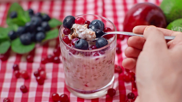 cropped view of man holding spoon with berries, granola and yogurt - Footage, Video