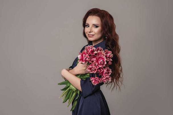 Mother's day concept. Portrait of charming cute lovely with toothy smile woman holding nice bouquet of beautiful  tulips isolated on gray background.fashion and beauty concept. - Photo, Image