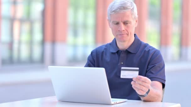 Відкритий середнього віку бізнесмен використовує кредитну картку на ноутбуці
 - Кадри, відео