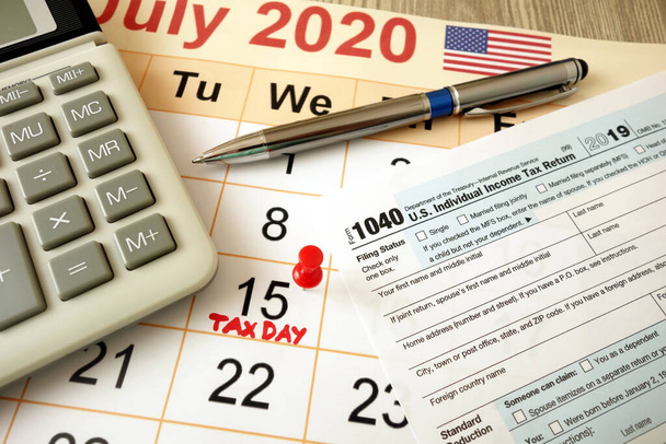 Měsíční kalendář s datem 15. července 2020 označen jako daňový den s kalkulačkou a perem 1040 - Fotografie, Obrázek