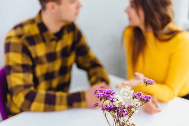 Cropped shot of romantic couple having romantic dinner on special event. Focus on violet flowers on the forefront. - Foto, Bild