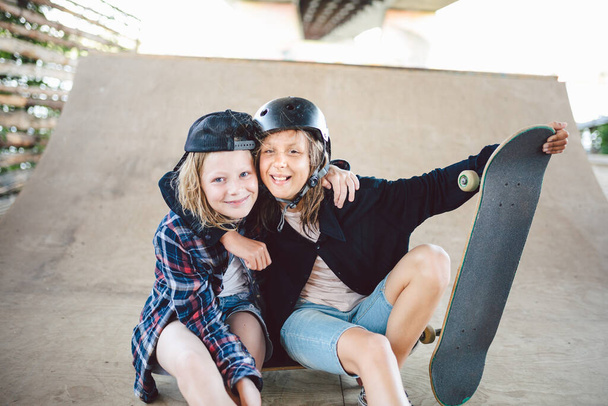 Grupo de amigos atletas skateboarders posando juntos en un parque de skate. Los niños caucásicos se divierten juntos en deportes urbanos al aire libre para el skateboarding. Club deportivo para niños
. - Foto, imagen
