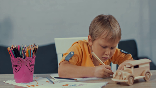 χαριτωμένο αγόρι κρατώντας μολύβι χρώμα και σχέδιο στο σπίτι - Πλάνα, βίντεο