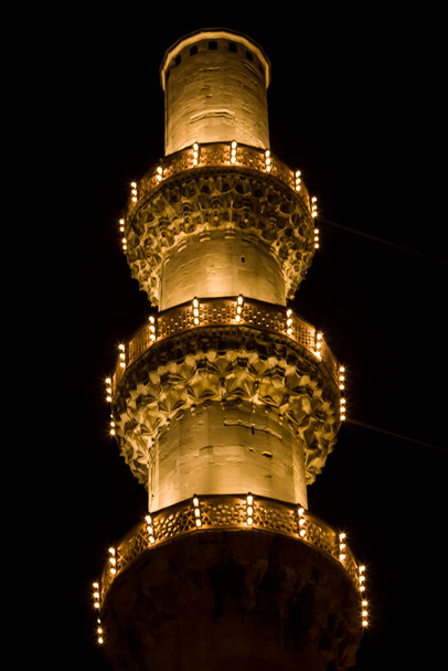 A varanda minarete da Mesquita Suleymaniye à noite no céu preto.Todas as luzes estão acesas.Conceito de religião islâmica
 - Foto, Imagem