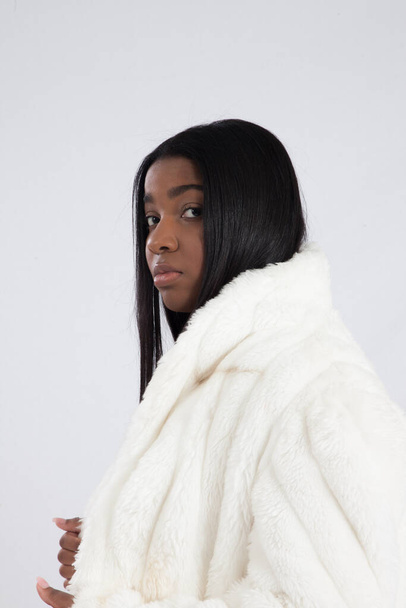 白い毛皮のコートを着た可愛い黒人女性 - 写真・画像