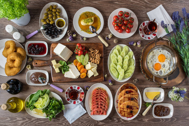 Traditioneel Turks ontbijt geserveerd met traditionele Turkse thee op houten tafel - Foto, afbeelding