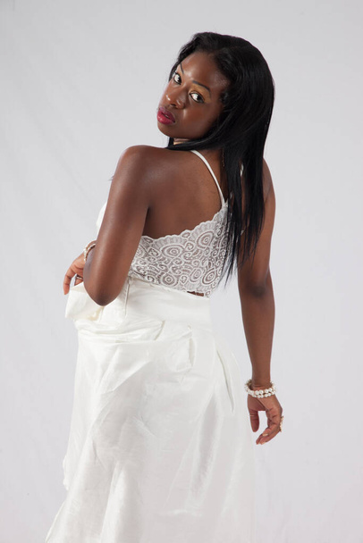 Pensive Schwarze Frau in einem weißen Kleid - Foto, Bild