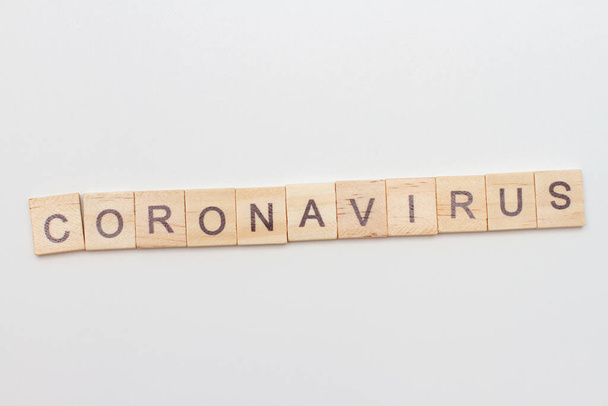 Inscripción Coronavirus escrito bloques de madera sobre fondo blanco. Concepto COVID
. - Foto, Imagen