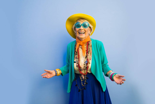Happy and playful senior woman having fun - Portrait of a beautiful lady above 70 years old with stylish clothes, concepts about senior people - Photo, Image