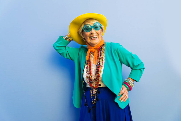 Happy and playful senior woman having fun - Portrait of a beautiful lady above 70 years old with stylish clothes, concepts about senior people - Photo, image