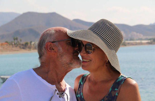 Szczęśliwa para seniorów uśmiechnięta, ciesząca się spacerem wzdłuż wybrzeża Morza Śródziemnego - Zdjęcie, obraz