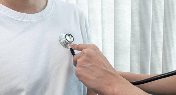 Hastanenin muayene odasındaki hastaların kalp atışlarını, fiziksel muayeneyi veya sağlık muayenesi konseptini kontrol etmek için stetoskopla sphygmomanometre kullanan doktor. - Fotoğraf, Görsel