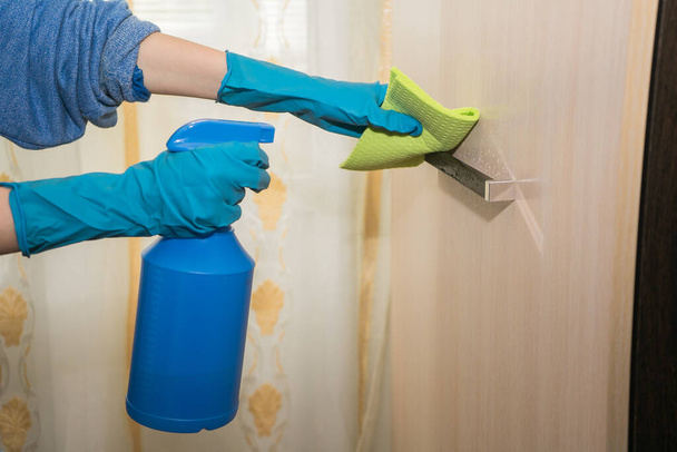 A girl in gloves disinfects the surface with a sanitizer antiseptic.  - Foto, imagen