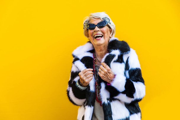 Happy and playful senior woman having fun - Portrait of a beautiful lady above 70 years old with stylish clothes, concepts about senior people - Foto, Bild