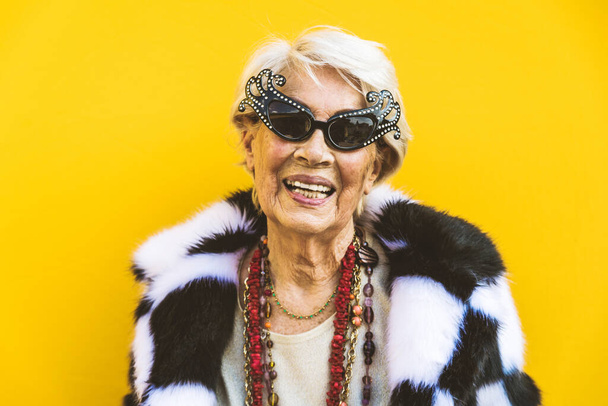 Happy and playful senior woman having fun - Portrait of a beautiful lady above 70 years old with stylish clothes, concepts about senior people - Foto, Imagem
