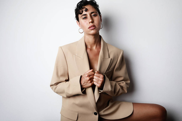 Sexy beautiful woman fashion glamour model brunette hair, wear suit jacket clothes party style. Isolated white wall. - Foto, afbeelding