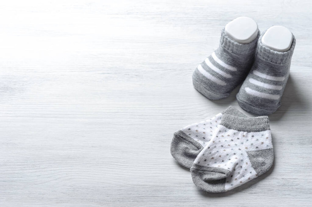 nuevos calcetines de bebé en tablero de madera blanco, concepto de recién nacido y bebé
 - Foto, Imagen