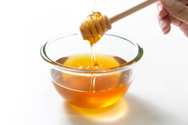 Abeja fresca de miel en tazón sobre fondo blanco
. - Foto, Imagen