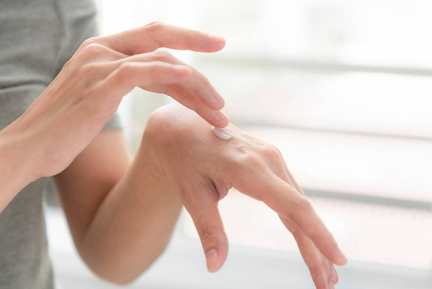 Closeup of hands applying moisturizer. Beauty woman holding care cream of skin cream. - Foto, Bild