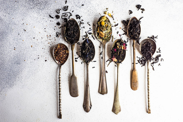 Varieties of tea in vintage spoons on concrete background with copy space - Photo, Image