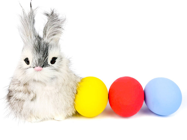 Un simpatico coniglietto dai capelli lunghi e luminoso uovo di Pasqua colorato, isolato su sfondo bianco.  - Foto, immagini
