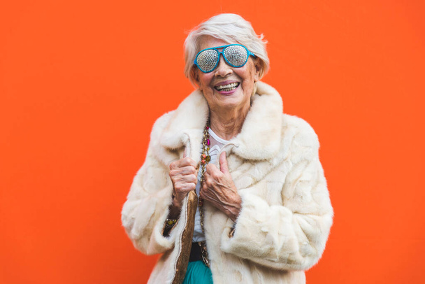 Happy and playful senior woman having fun - Portrait of a beautiful lady above 70 years old with stylish clothes, concepts about senior people - Foto, imagen