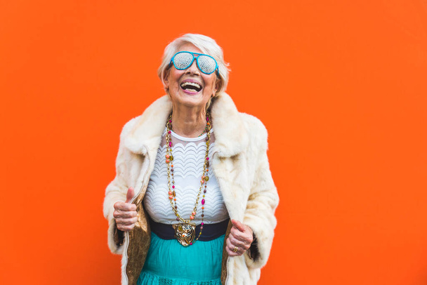Happy and playful senior woman having fun - Portrait of a beautiful lady above 70 years old with stylish clothes, concepts about senior people - Foto, Bild