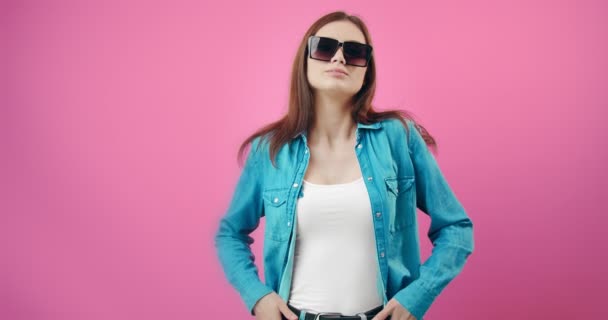 Stunning woman wearing trendy sunglasses and denim shirt - Filmati, video