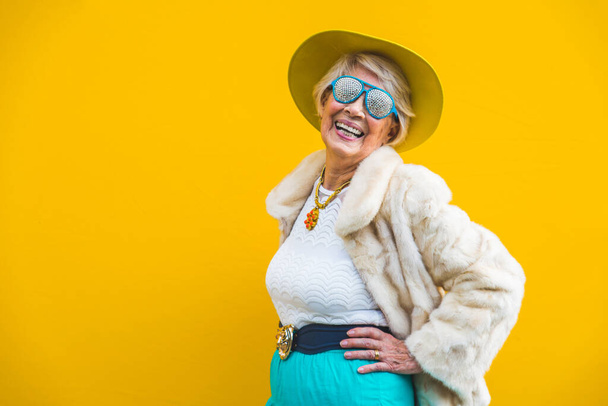 Happy and playful senior woman having fun - Portrait of a beautiful lady above 70 years old with stylish clothes, concepts about senior people - Photo, image