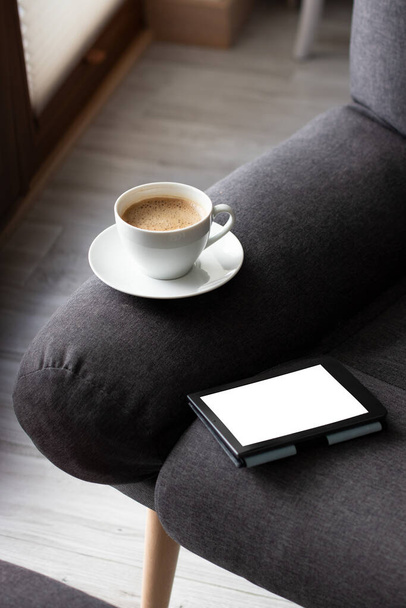 Mockup Ebook on soft modern armchair With Blank White Screen, to replace your design. Cup of Coffee for cozy atmosphere reading. Paste your book cover here - Foto, imagen