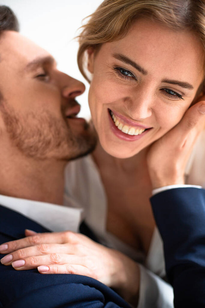 Happy passionate couple in love touching, kissing and huging. Focus on female happy eyes and hand in foreground. Enjoyment concept. Close up shot - Fotó, kép