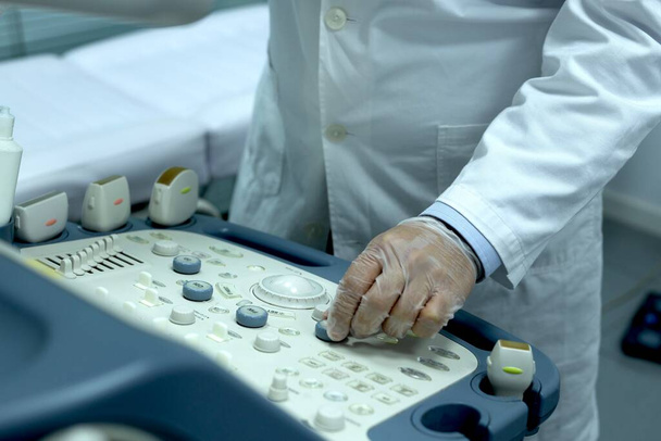 Zbliżenie lekarza używającego maszyny do wykonania USG u pacjenta z możliwymi zaburzeniami endokrynologicznymi - Zdjęcie, obraz