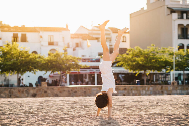 Petite fille faisant un handstand sur la plage - Photo, image