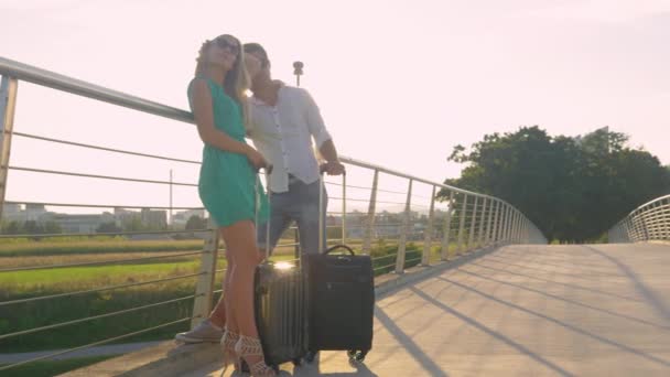レンズフレア:若いカップルは空港に彼らを連れて行くのを待っています. - 映像、動画