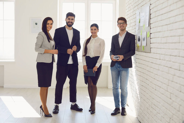 Young business people standing at a meeting in the office. - Foto, afbeelding