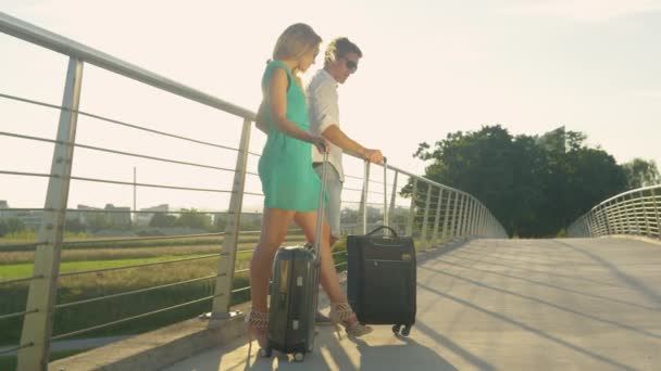 LENTE FLARE: raggi di sole dorati brillano sugli sposi che decidono di raggiungere a piedi l'aeroporto - Filmati, video