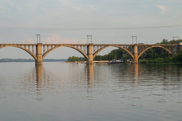 Eisenbahnbrücke über den Dnjepr in der Stadt Dnjepr bei Sonnenuntergang - Foto, Bild