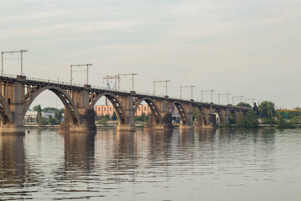 ponte ferroviária sobre o rio Dnieper na cidade de Dnieper ao pôr do sol
 - Foto, Imagem