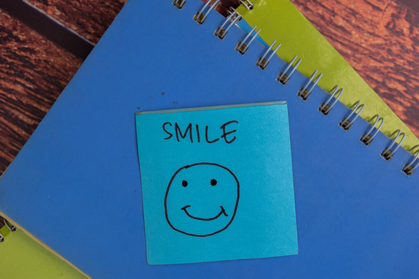 Smile Face κείμενο σε αυτοκόλλητες σημειώσεις που απομονώνονται στο γραφείο. - Φωτογραφία, εικόνα