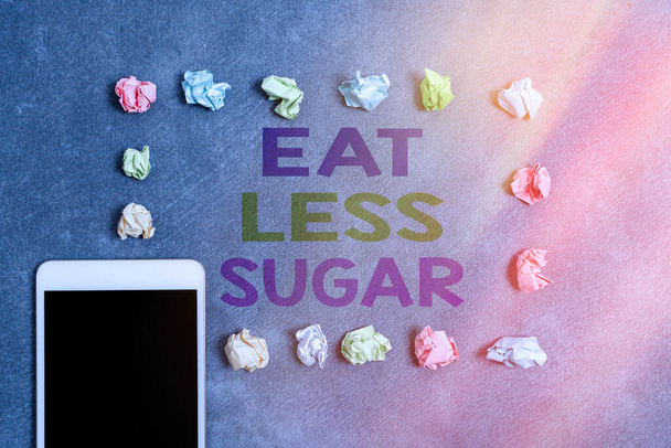Kirjoitan viestiä, jossa lukee Syö vähemmän sokeria. Business valokuva esittelee vähentää sokerin saanti ja syö terveellistä ruokavaliota runsaasti elintarvikkeita Paperi tarvikkeet älypuhelimella järjestetty eri tausta. - Valokuva, kuva